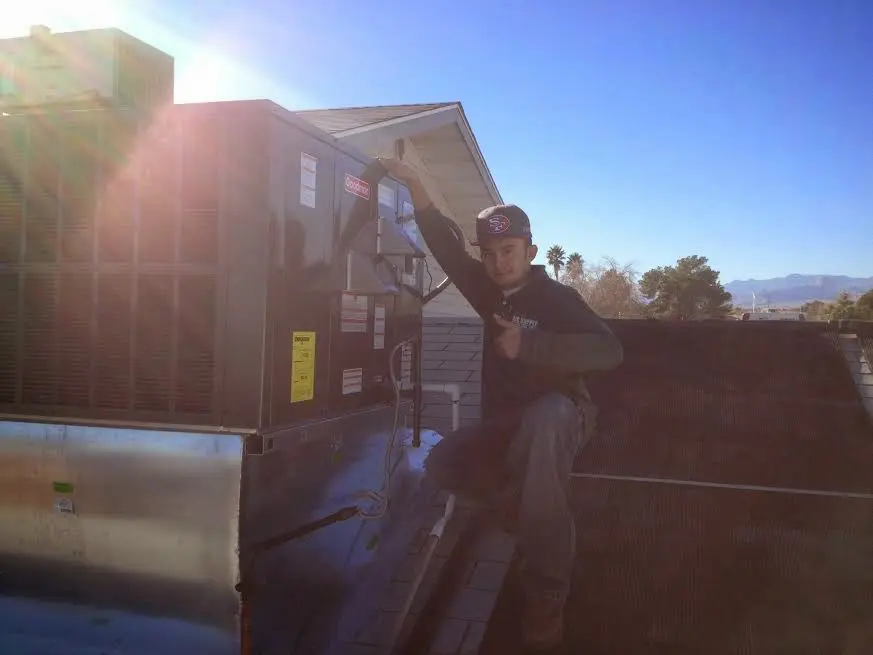 HVAC technician performing Heat Pump Repair on a rooftop unit in Lyman