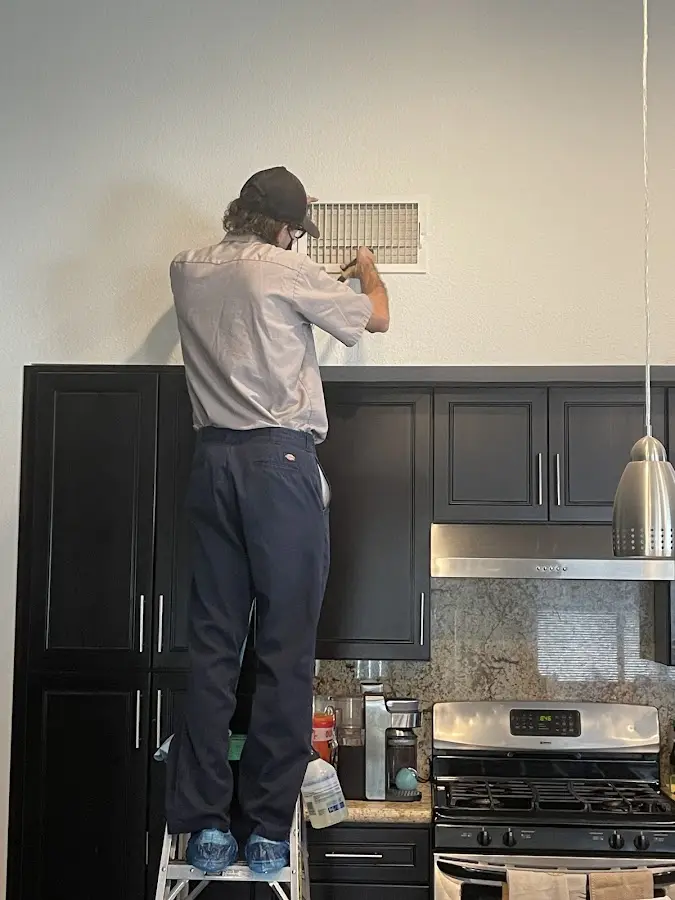 Technician inspecting an air vent during HVAC service in Lyman